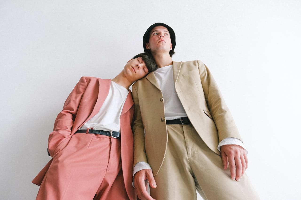 about-us Low-angle portrait of two men in stylish pastel suits, showcasing modern fashion.